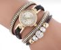 Gold watch with a black bracelet, strap wrapped