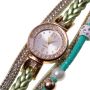 Gold watch with a green bracelet, strap wrapped
