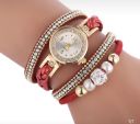 Gold watch with a red bracelet, strap wrapped