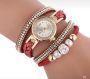 Gold watch with a red bracelet, strap wrapped